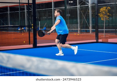 Middle age man palying padel on outdoor court. - Powered by Shutterstock