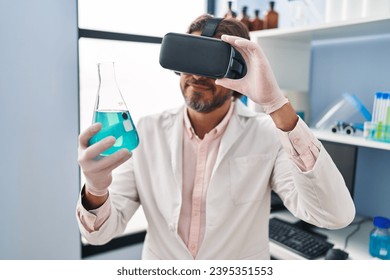 Middle age man scientist using virtual reality glasses holding test tube at laboratory - Powered by Shutterstock