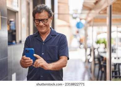 Middle age man smiling confident using smartphone at street - Powered by Shutterstock