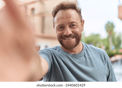 Middle age man smiling confident making selfie by camera at street - Powered by Shutterstock