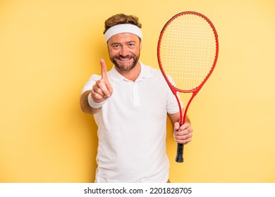 Middle Age Man Smiling Proudly And Confidently Making Number One. Tennis Concept