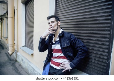 middle age man smoking cigarette on backjard, stylish tough guy, lifestyle people concept