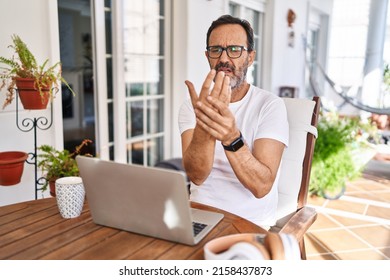 Middle Age Man Using Computer Laptop At Home Suffering Pain On Hands And Fingers, Arthritis Inflammation 