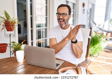 Middle Age Man Using Computer Laptop At Home Clapping And Applauding Happy And Joyful, Smiling Proud Hands Together 