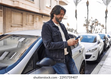 Middle age man using smartphone leaning on car at street - Powered by Shutterstock