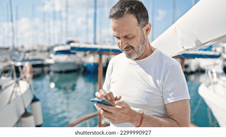 Middle age man using smartphone with serious expression at boat - Powered by Shutterstock