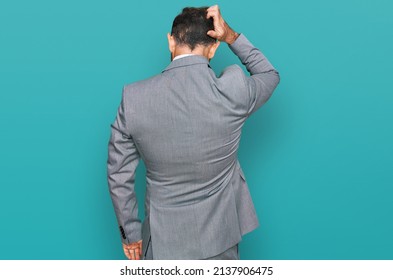 Middle Age Man Wearing Business Clothes Backwards Thinking About Doubt With Hand On Head 