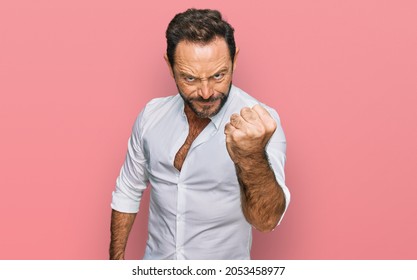 Middle age man wearing casual clothes angry and mad raising fist frustrated and furious while shouting with anger. rage and aggressive concept.  - Shutterstock ID 2053458977