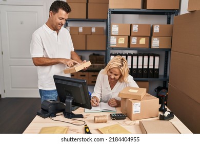 Middle Age Man And Woman Business Partners Holding Package Working At Storehouse