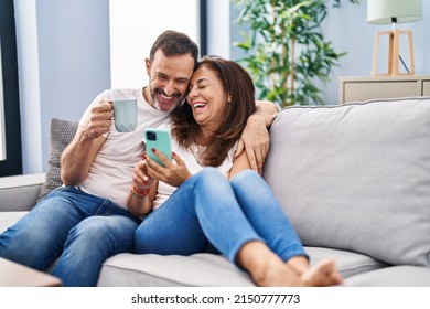 Middle age man and woman couple using smartphone and drinking coffee at home - Powered by Shutterstock