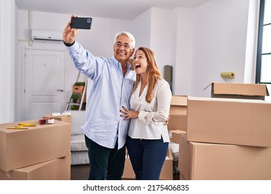 Middle Age Man And Woman Couple Make Selfie By The Smartphone At New Home