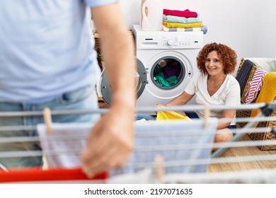 Middle Age Man And Woman Couple Smiling Confident Hanging Clothes At Laundry