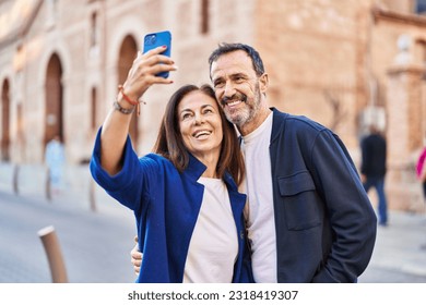 Middle age man and woman couple make selfie by the smartphone at street - Powered by Shutterstock