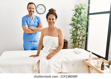 Middle Age Man And Woman Smiling Confident Wearing Therapist Uniform At Beauty Center