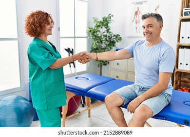 Middle age man and woman wearing physiotherapy uniform having rehab session shake hands at physiotherapy clinic - Powered by Shutterstock