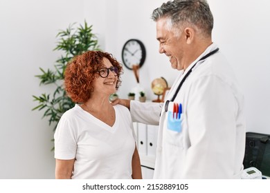 Middle age man and woman wearing doctor uniform having medical consultation at clinic