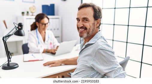 Middle age man and woman wearing doctor uniform having medical consultation at clinic - Shutterstock ID 2195910183