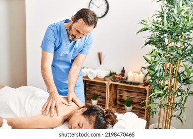 Middle Age Man And Woman Wearing Therapist Uniform Having Back Massage Session At Beauty Center