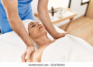 Middle Age Man And Woman Wearing Therapist Uniform Having Shoulders Massage Session At Beauty Center