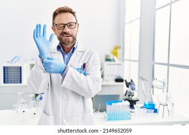 Middle Age Man Working At Scientist Laboratory Winking Looking At The Camera With Sexy Expression, Cheerful And Happy Face. 