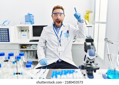 Middle Age Man Working At Scientist Laboratory Pointing Finger Up With Successful Idea. Exited And Happy. Number One. 