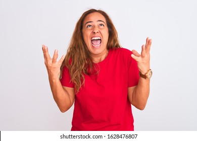 Middle Age Mature Woman Standing Over White Isolated Background Crazy And Mad Shouting And Yelling With Aggressive Expression And Arms Raised. Frustration Concept.