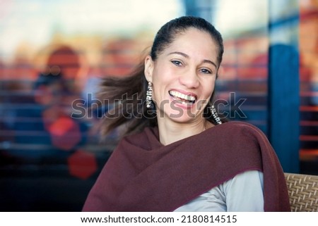 middle age mixed race woman with a great tooth smile sitting at a cafe