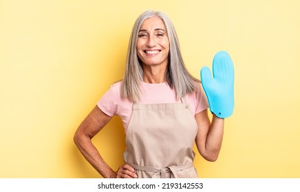 Middle Age Pretty Woman Smiling Happily With A Hand On Hip And Confident. Oven Mitt Concept