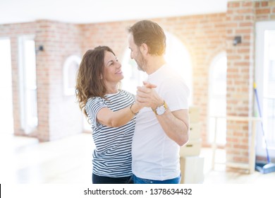 Middle Age Senior Couple Moving To A New House, Dancing And Smiling Happy In Love With Apartmant