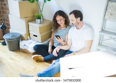 Middle Age Senior Couple Moving To A New Home Using Smartphone With A Confident Expression On Smart Face Thinking Serious