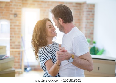 Middle Age Senior Couple Moving To A New House, Dancing And Smiling Happy In Love With Apartmant