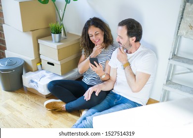 Middle Age Senior Couple Moving To A New Home Using Smartphone Serious Face Thinking About Question, Very Confused Idea