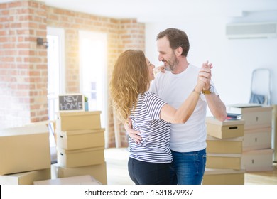 Middle Age Senior Couple Moving To A New House, Dancing And Smiling Happy In Love With Apartmant