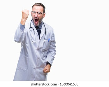 Middle age senior hoary doctor man wearing medical uniform isolated background angry and mad raising fist frustrated and furious while shouting with anger. Rage and aggressive concept. - Shutterstock ID 1360041683