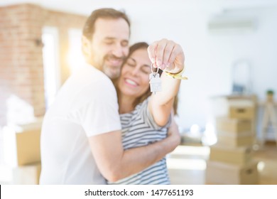 Middle age senior romantic couple holding and showing house keys smiling happy for moving to a new home - Shutterstock ID 1477651193