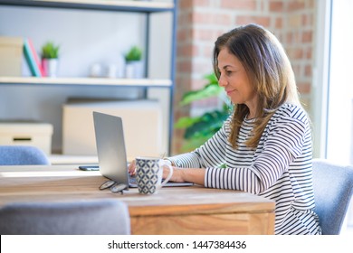 Middle age senior woman sitting at the table at home working using computer laptop with a confident expression on smart face thinking serious