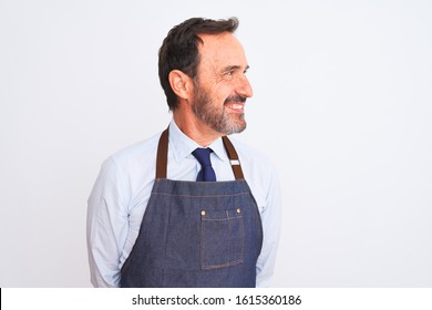 Middle age shopkeeper man wearing apron standing over isolated white background looking away to side with smile on face, natural expression. Laughing confident. - Powered by Shutterstock