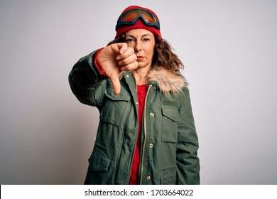 Middle Age Skier Woman Wearing Snow Sportswear And Ski Goggles Over White Background Looking Unhappy And Angry Showing Rejection And Negative With Thumbs Down Gesture. Bad Expression.