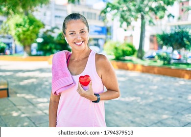 Middle Age Sportswoman Asking For Health Care Holding Heart At The Park