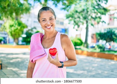 Middle Age Sportswoman Asking For Health Care Holding Heart At The Park