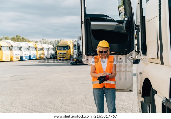 Middle age truck driver woman puts on gloves,\
trucker occupation in Europe for\
females