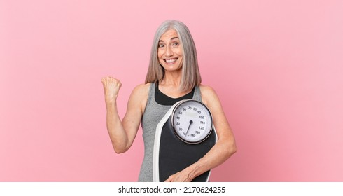 middle age white hair woman holding a weight scale. fitness and diet concept - Powered by Shutterstock