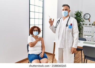 Middle Age Woman Getting Vaccine By Doctor Thinking Attitude And Sober Expression Looking Self Confident 