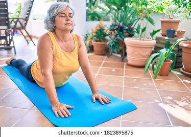 Middle Age Woman With Grey Hair Smiling Happy Doing Exercise And Stretching On The Terrace At Home