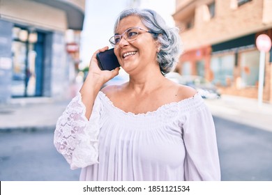 Middle Age Woman With Grey Hair Smiling Happy Outdoors Speaking On The Phone