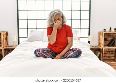 Middle Age Woman With Grey Hair Sitting On The Bed At Home Tired Rubbing Nose And Eyes Feeling Fatigue And Headache. Stress And Frustration Concept. 