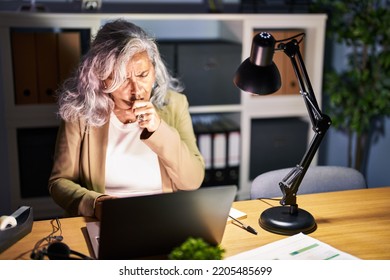 Middle Age Woman With Grey Hair Working Using Computer Laptop Late At Night Feeling Unwell And Coughing As Symptom For Cold Or Bronchitis. Health Care Concept. 