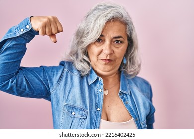 Middle Age Woman With Grey Hair Standing Over Pink Background Strong Person Showing Arm Muscle, Confident And Proud Of Power 