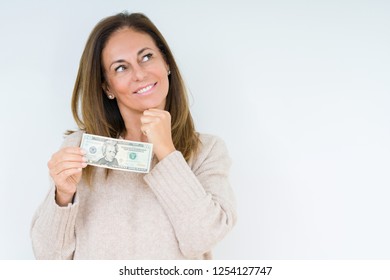 Middle age woman holding 20 dollars bank note over isolated background serious face thinking about question, very confused idea - Shutterstock ID 1254127747