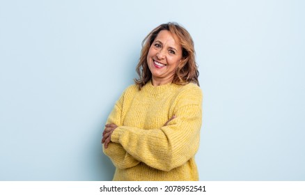 middle age woman laughing happily with arms crossed, with a relaxed, positive and satisfied pose